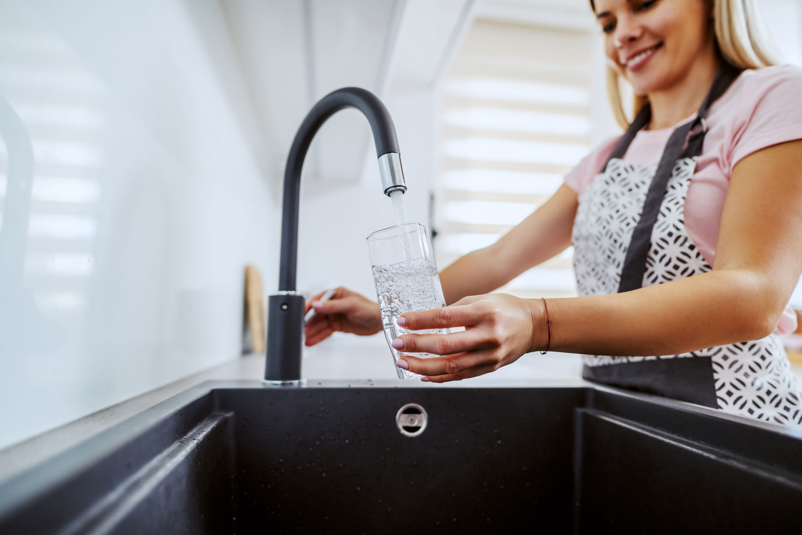 Lady runing tap water into glass 3000x2000 scaled